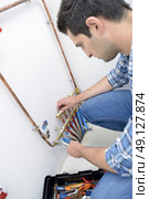 Plumber fixing a water system. Стоковое фото, агентство Ingram Publishing / Фотобанк Лори