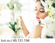 Alluring brunette sitting on the flowery seesaw. Стоковое фото, агентство Ingram Publishing / Фотобанк Лори