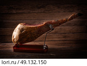 Iberian ham pata negra from Spain on wood background. Стоковое фото, агентство Ingram Publishing / Фотобанк Лори