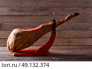 Iberian ham pata negra from Spain on wood background. Стоковое фото, агентство Ingram Publishing / Фотобанк Лори