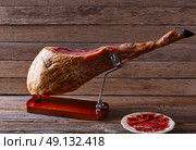 Iberian ham pata negra from Spain on wood background. Стоковое фото, агентство Ingram Publishing / Фотобанк Лори
