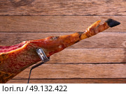 Iberian ham pata negra from Spain on wood background. Стоковое фото, агентство Ingram Publishing / Фотобанк Лори