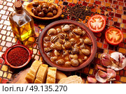 Tapas snail recipe from Spain in clay plate. Стоковое фото, агентство Ingram Publishing / Фотобанк Лори