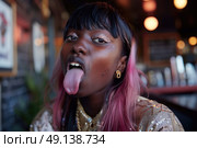 A woman with vibrant pink hair playfully sticks out her tongue, expressing a carefree and fun attitude. Стоковое AI-изображение, AI-художник Данила Большаков / Фотобанк Лори