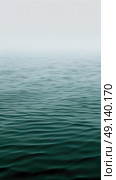 A large expanse of water with the sky in the background, creating a serene and expansive scene. Стоковое AI-изображение, AI-художник Данила Большаков / Фотобанк Лори