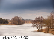 Spring rural scene. Lake under ice and snow melting. Cloudy spring day. Early spring. Mud season. Стоковое фото, агентство Ingram Publishing / Фотобанк Лори