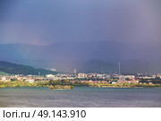 Town on the lake behind the foothills. Spring rain and storm in mountains. Green spring hills of Slovakia. Spring stormy scene. Стоковое фото, агентство Ingram Publishing / Фотобанк Лори