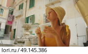 Woman sips coffee at outdoor cafe in Atrani old town during summer holidays. Стоковое видео, видеограф Ольга Сухарева / Фотобанк Лори