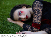 Halloween kid girl custome with bloody makeup on backyard turf. Стоковое фото, агентство Ingram Publishing / Фотобанк Лори