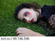 Halloween kid girl custome with bloody makeup on backyard turf. Стоковое фото, агентство Ingram Publishing / Фотобанк Лори