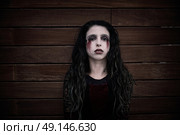 Halloween kid girl custome with bloody makeup on wooden wall. Стоковое фото, агентство Ingram Publishing / Фотобанк Лори