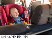 Father fasten his little baby in the car seat. Стоковое фото, агентство Ingram Publishing / Фотобанк Лори