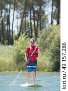 man enjoying a ride on the lake with paddleboard. Стоковое фото, агентство Ingram Publishing / Фотобанк Лори