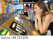 Miserable woman sat at arcade game. Стоковое фото, агентство Ingram Publishing / Фотобанк Лори