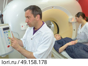 nurse and doctor as they prepare for an axial tomography. Стоковое фото, агентство Ingram Publishing / Фотобанк Лори