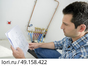 Man looking at wiring instructions. Стоковое фото, агентство Ingram Publishing / Фотобанк Лори