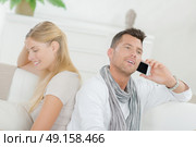Couple at home, man on cellphone. Стоковое фото, агентство Ingram Publishing / Фотобанк Лори