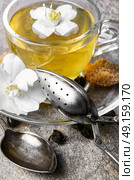 herbal tea with Jasmine flowers. glass of herbal tea with the aroma of Jasmine flower on stone background. Стоковое фото, агентство Ingram Publishing / Фотобанк Лори