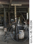 Penny farthing bicycle in workshop, Sherbrooke, Nova Scotia, Canada. Стоковое фото, агентство Ingram Publishing / Фотобанк Лори