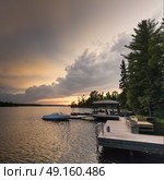 Boats moored at a dock in the lake, Lake of The Woods, Ontario, Canada. Стоковое фото, агентство Ingram Publishing / Фотобанк Лори
