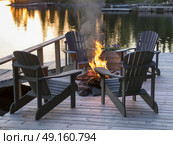 Adirondack chairs and campfire on a dock, Lake of The Woods, Ontario, Canada. Стоковое фото, агентство Ingram Publishing / Фотобанк Лори