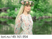 Beautiful blonde woman with flower wreath on her head. Beauty girl with flowers hairstyle. Girl in a summer forest. Fashion photo. Стоковое фото, агентство Ingram Publishing / Фотобанк Лори