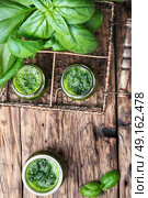 healthy green smoothie with basil. Freshly blended green basil smoothie in glass jar on wooden table. Стоковое фото, агентство Ingram Publishing / Фотобанк Лори