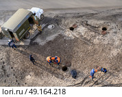Top view of workers repairing underground heating mains through open hatches, the inscription on the truck: 'Emergency heating service' Стоковое фото, фотограф Сергей Фролов / Фотобанк Лори