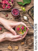 Tea with raspberries. Tea cup with raspberry warming tea in hands. Стоковое фото, агентство Ingram Publishing / Фотобанк Лори