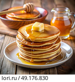 A mouthwatering stack of fluffy pancakes is served on a white plate, topped with a pat of butter and drizzled with honey. A wooden bowl and jar filled with syrup add to the cozy breakfast atmosphere. Стоковое AI-изображение, AI-художник Ольга Игнашина / Фотобанк Лори