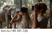 Child using virtual reality headset for metaverse, child looking into VR glasses. Little girl boy with futuristic glasses having fun, teenager playing video games. Technology, simulator, oculus future. Стоковое AI-изображение, AI-художник ALLA YURTAYEVA / Фотобанк Лори