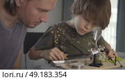 Father teaching his little son to solder electronic contacts at home. Стоковое видео, видеограф Скоробогатова Е. / Фотобанк Лори