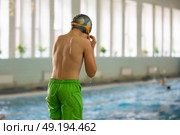 A boy in a swimming cap and goggles dives into a sports pool. Стоковое фото, фотограф Лазаренко Светлана / Фотобанк Лори