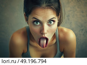 Charming woman looking at camera with humorous expression, sticking her tongue out, while wearing casual clothing in indoor setting. Стоковое AI-изображение, AI-художник Данила Большаков / Фотобанк Лори