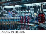 A table is filled with numerous bottles that contain various liquids. Стоковое AI-изображение, AI-художник Данила Большаков / Фотобанк Лори