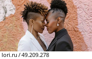 Two women of different ethnicities standing side by side in front of a blank wall. Стоковое AI-изображение, AI-художник Данила Большаков / Фотобанк Лори