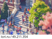 A vibrant group of students gathers and chats on the steps of a historic university building surrounded by lush greenery. Some are ascending while others linger, enjoying the sunny morning. Стоковое AI-изображение, AI-художник Данила Большаков / Фотобанк Лори