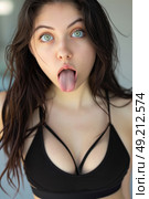 A woman sticking out her tongue in a humorous manner, creating a funny expression with her face. Стоковое AI-изображение, AI-художник Данила Большаков / Фотобанк Лори