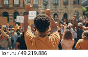 Large group of people raising various signs above their heads in a collective display of activism and protest. Стоковое AI-изображение, AI-художник Данила Большаков / Фотобанк Лори
