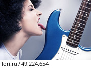 Rocker lady licking a guitar. Стоковое фото, агентство Ingram Publishing / Фотобанк Лори