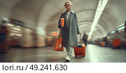 A bright, stylish commercial image a fashionable elderly woman (55-60) hurries through a Moscow metro station. Стоковое AI-изображение, AI-художник Ярославский Максим / Фотобанк Лори