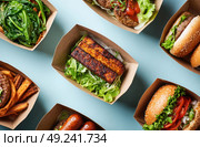 A variety of food items are displayed in paper containers, including sandwiches. Стоковое AI-изображение, AI-художник Ярославский Максим / Фотобанк Лори