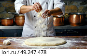 The cook prepares the dough for the product in the form of a pizza. The chef makes pizza for the customers. The pizza maker prepares pizza dough. Стоковое AI-изображение, AI-художник Антон Слабоспицкий / Фотобанк Лори