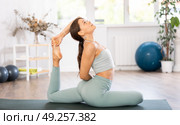 Experienced girl fitness club teacher performs pigeon asana, eka pada rajakapotasana. Стоковое фото, фотограф Яков Филимонов / Фотобанк Лори