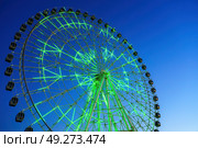 High neon ferris wheel at night in an amusement park Navruz or Anhor in Tashkent, Uzbekistan. (2023 год). Стоковое фото, фотограф Емельянов Евгений Викторович / Фотобанк Лори