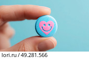 A person is holding a blue and pink pill shaped like a heart. Стоковое AI-изображение, AI-художник Ярославский Максим / Фотобанк Лори