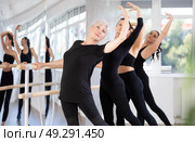 Senior woman performing battement tendu at barre during group rehearsal. Стоковое фото, фотограф Яков Филимонов / Фотобанк Лори