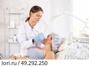 Aesthetician administering hardware facial procedure with ice hammer on young woman. Стоковое фото, фотограф Яков Филимонов / Фотобанк Лори