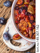 meat in plum sauce. meat stew in a sauce of autumn plums on a retro background. Стоковое фото, агентство Ingram Publishing / Фотобанк Лори