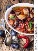 stew meat in plum sauce. meat stew in sauce of autumn plums on a retro background. Стоковое фото, агентство Ingram Publishing / Фотобанк Лори